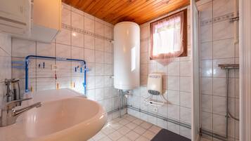 A bathroom with a sink, a shower, and a toilet.