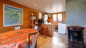 A cozy cabin interior with a dining area, kitchen, and a large map on the wall.