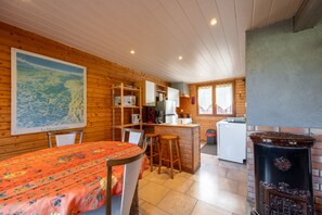 A cozy cabin interior with a dining area, kitchen, and a large map on the wall.
