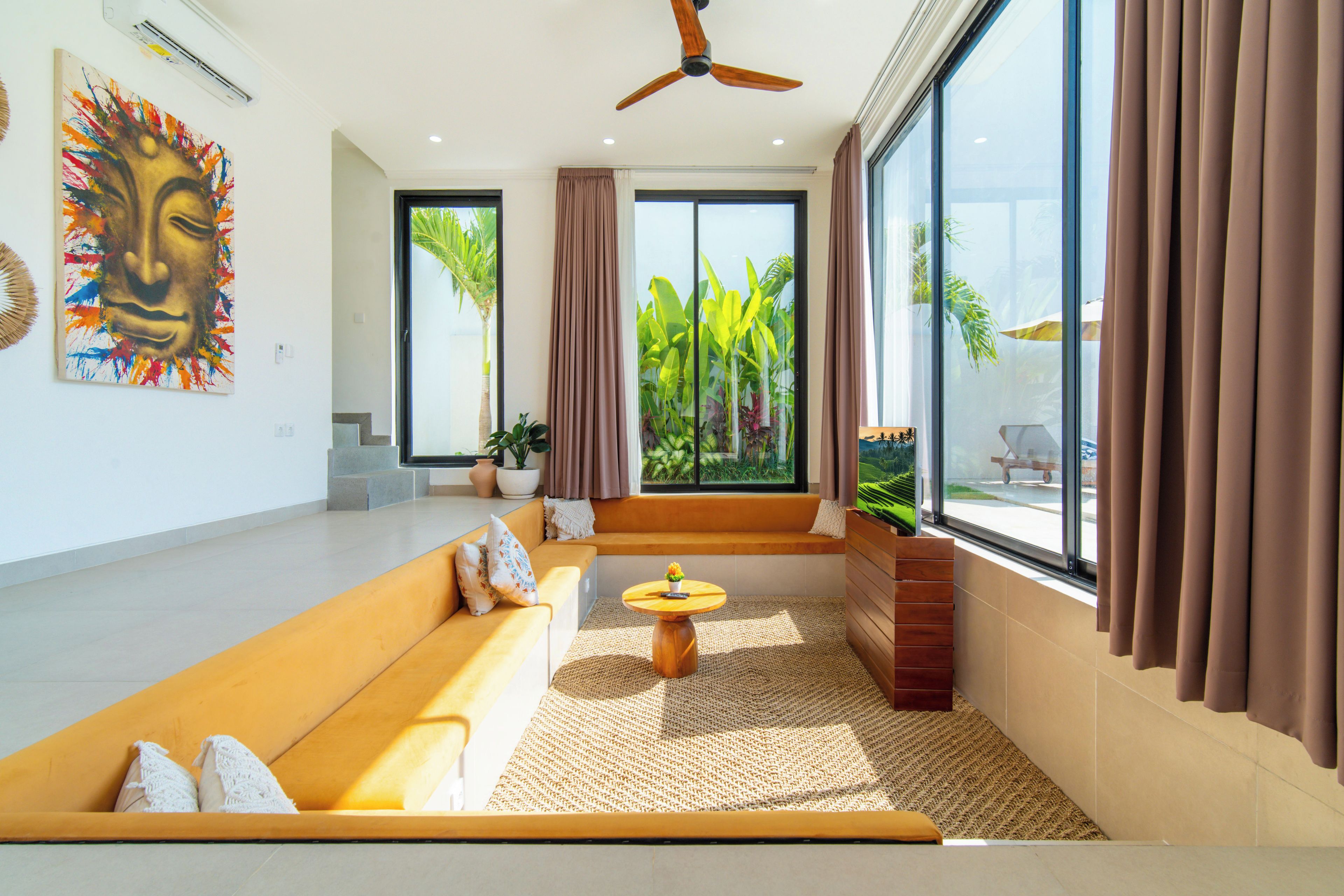 A modern living room with a sofa, a coffee table, and a large window with curtains.