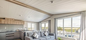 Eine moderne Küche mit Essbereich, großen Fenstern und Blick ins Freie.