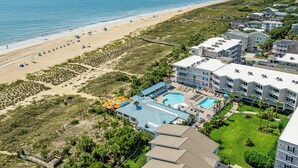 Ein Küstenhotel mit Blick auf den Strand, einem Schwimmbad und mehreren Gästezimmern.