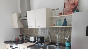 Een moderne keuken met witte kasten, een roestvrijstalen spoelbak en een inbouwoven.