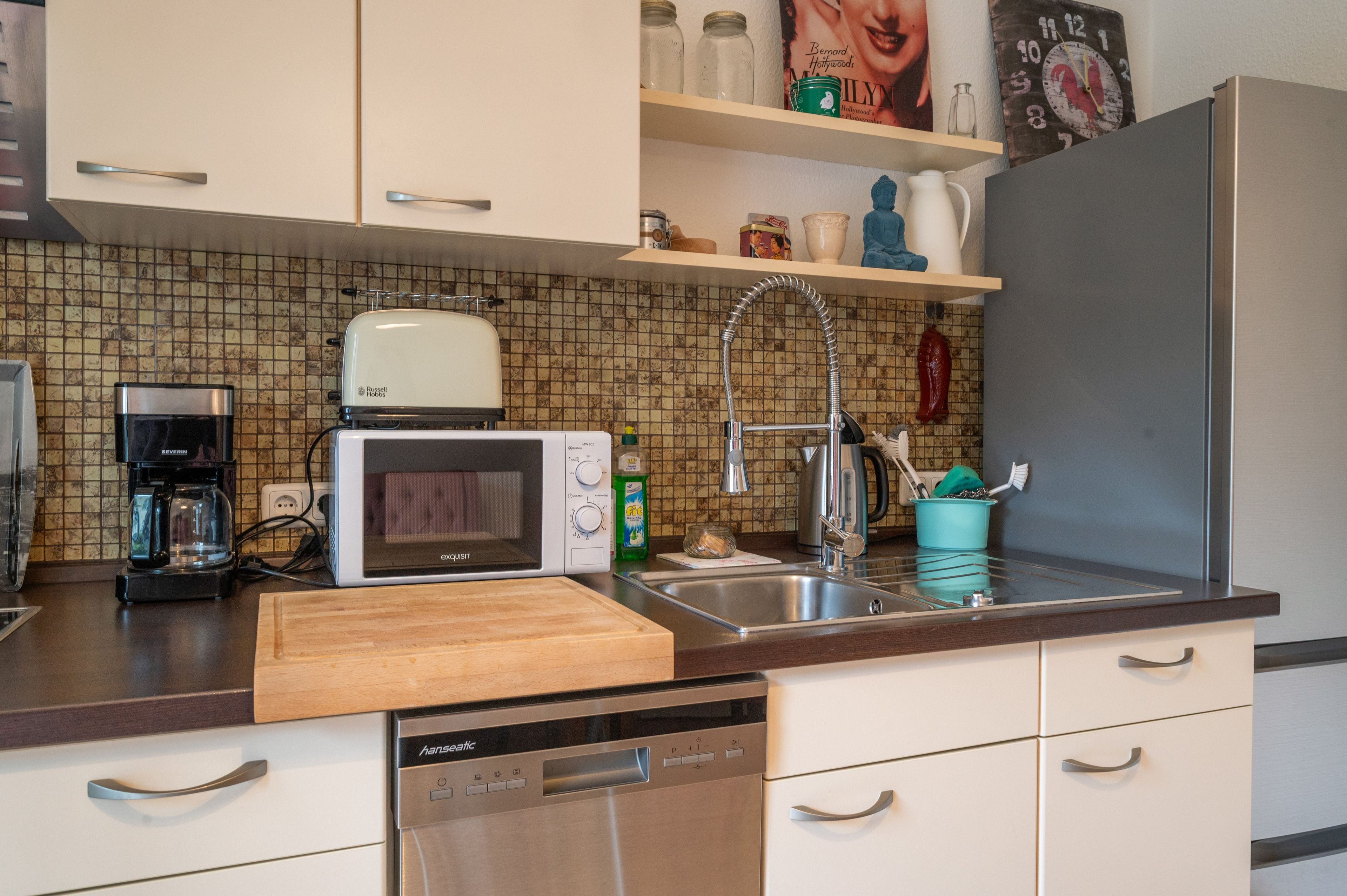 Una cocina equipada con microondas, tostadora, fregadero y lavavajillas.