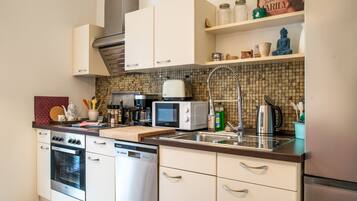 A modern kitchen with stainless steel appliances, a microwave, a toaster, and a kettle.