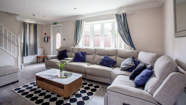 Ein Wohnzimmer mit einer Couch, einem Couchtisch und einem gemusterten Teppich.