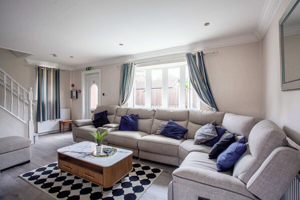 A living room with a sofa, coffee table, and patterned rug. - Peaceful Countryside Lodge: Scenic Views & (Barnsley)