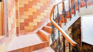 A staircase with a wooden handrail and ornate metal balusters. - Collection O GNRC Hospital Dispur (Guwahati)