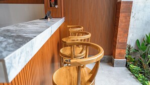 Eine Bar mit einer Marmorplatte und Holzhockern.