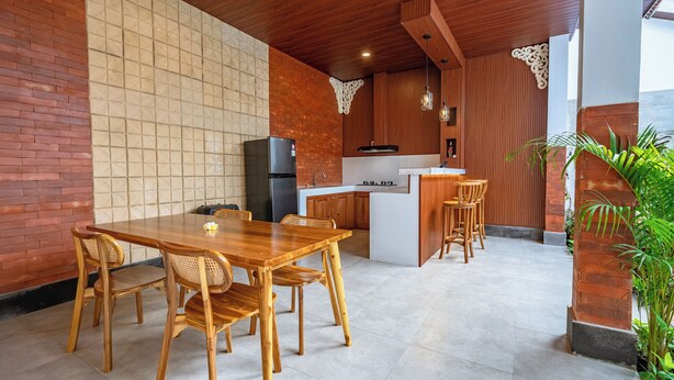 Eine moderne Küche mit Essbereich aus Holz, einem Kühlschrank und einer Bar.