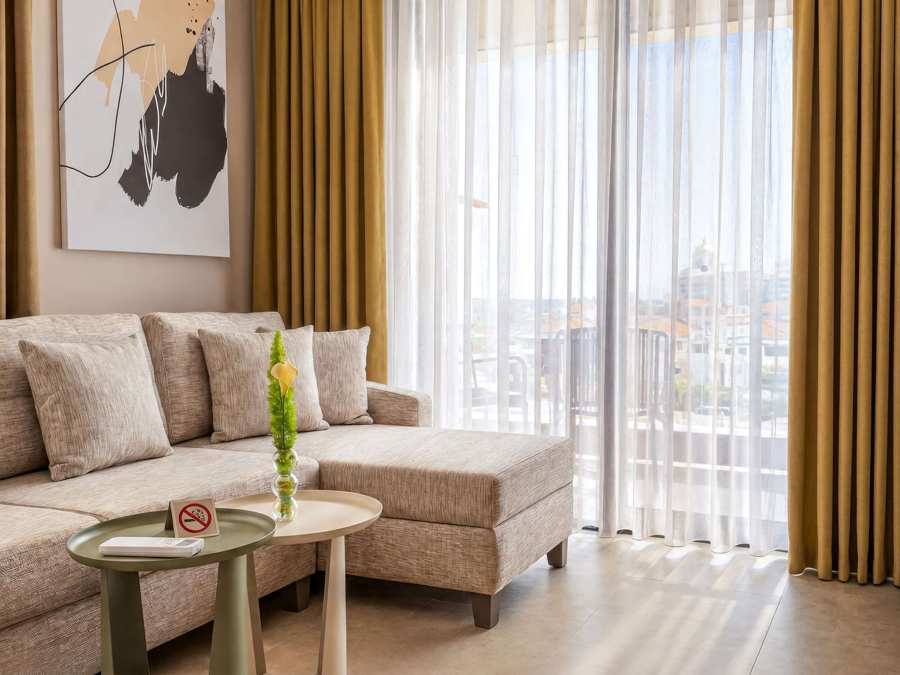 A modern living room with a sofa, a small table, and a vase with a plant.