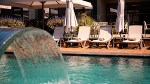 Ein Poolbereich mit Liegestühlen und Sonnenschirmen.