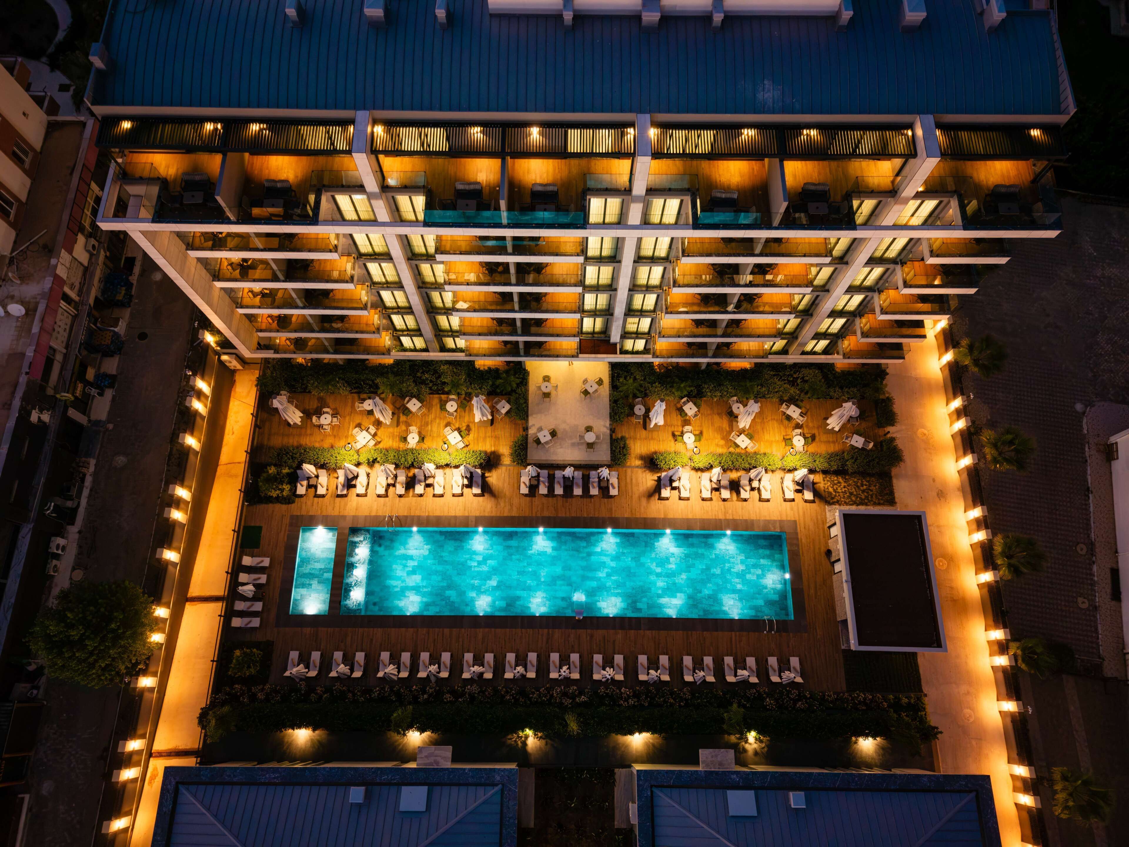 Une piscine sur le toit, dotée de chaises longues et d’un espace salon abrité.