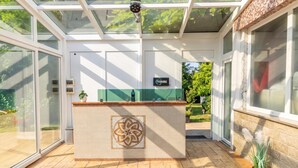 A reception area with a tiled counter, glass doors, and a sign above. - Paradise Forest Glamping Rooms (Koper)