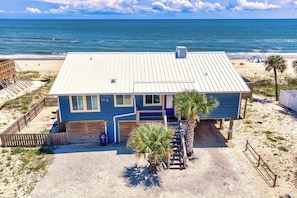 A beachfront house with a metal roof, large windows, and a small porch. - Sea Ya! Beach Front! Pet Friendly! Hot Tub! (St. George Island)