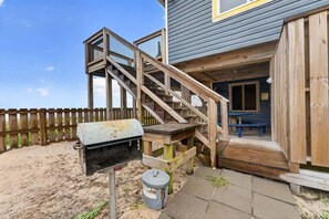 A wooden deck with a barbecue grill and a trash can. - Sea Ya! Beach Front! Pet Friendly! Hot Tub! (St. George Island)