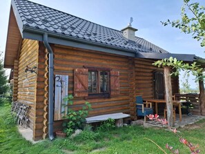 A log cabin with a sloped roof, a wooden porch, and a bench. - Cosy Cottage - Agrotourism Jizerska Zagroda (Gierczyn)