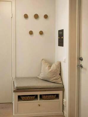 A room with a bench, wall-mounted keys, and a door.