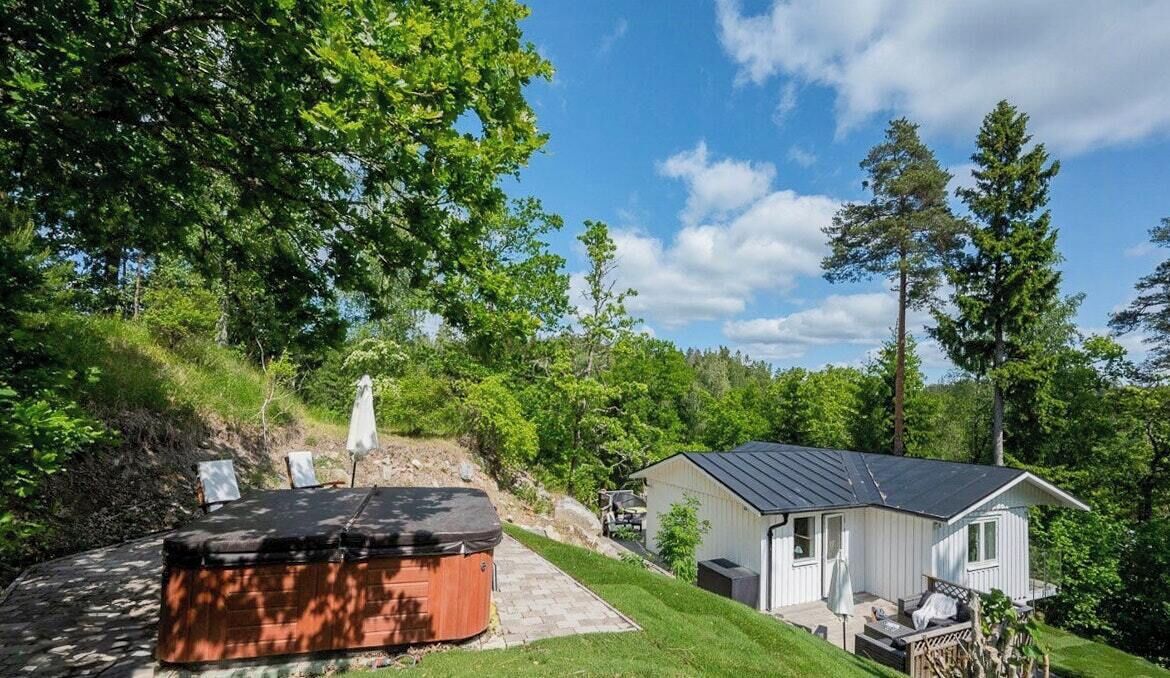 Ett hus med en uteplats, en bubbelpool och ett förråd.