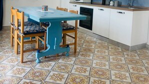 Eine kompakte Küche mit weißen Schränken, einer Mikrowelle, einem Toaster und einem Backofen.