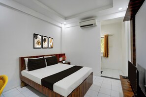 A hotel room with a bed, bedside table, and artwork on the wall. - Collection O Warje Pune Formerly Choice (Pune)