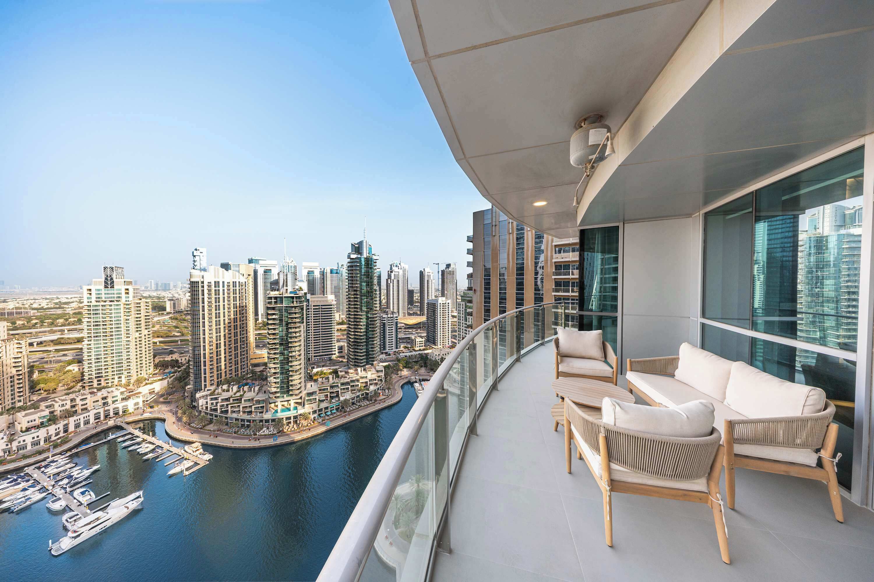 Un balcon avec vue sur une marina et des immeubles de grande hauteur.