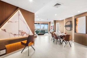 A modern dining area with a marble accent wall, a dining table set for six, and a view of the cityscape through large windows. - StayShort - Luxury 2BR with Marina Views | Sleeps 4 (Dubai)