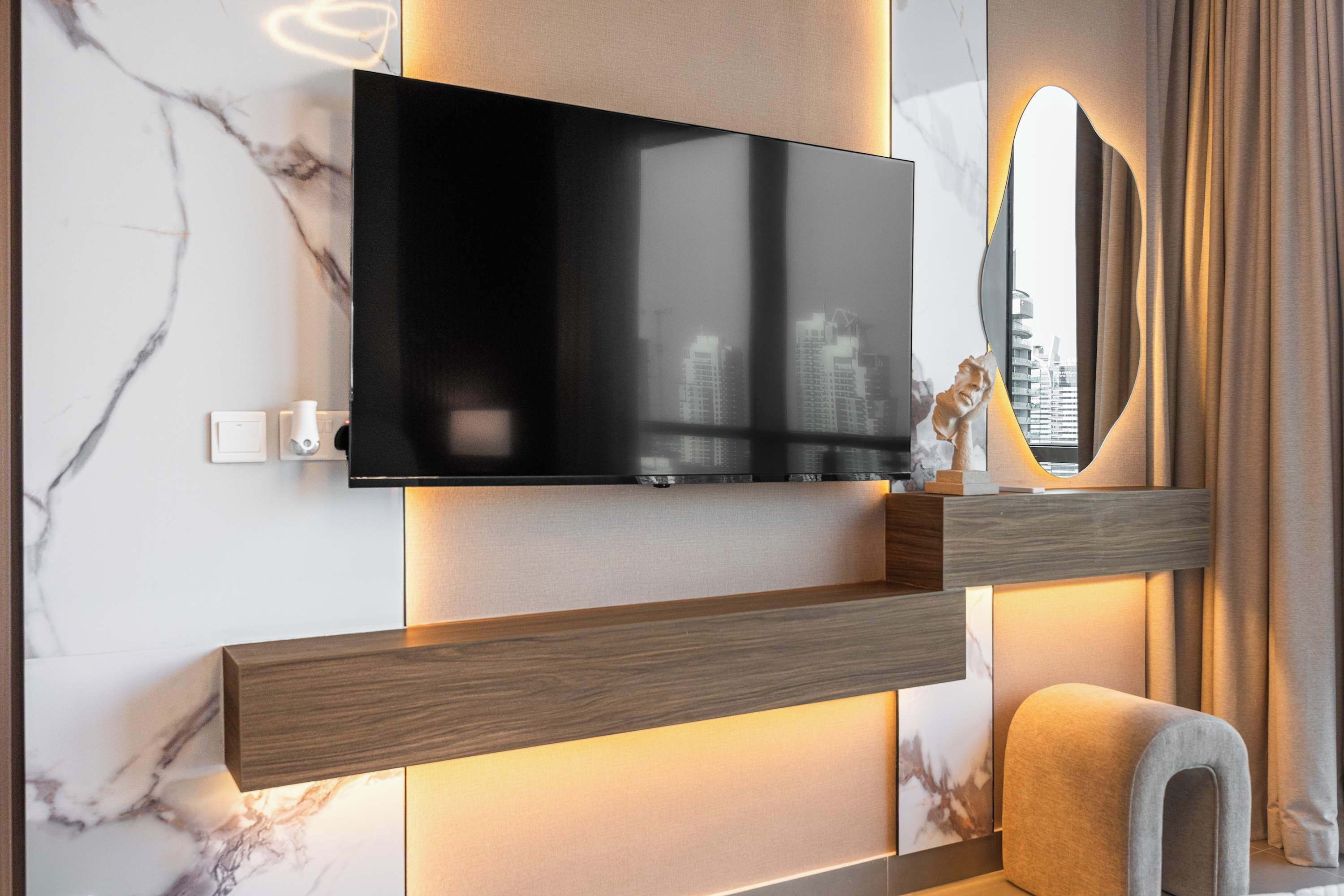 Une salle de bain moderne équipée d’un téléviseur fixé au mur, d’un miroir et d’un porte-serviettes.