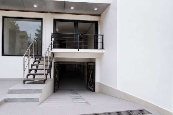 Una entrada de edificio moderno con una escalera que conduce a un balcón.