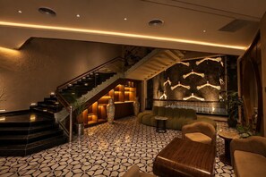 Eine moderne Lobby mit einem geometrisch gemusterten Boden, einer Treppe und einer Sitzecke mit Kamin.