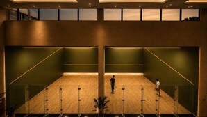 A spacious indoor area with a wooden floor, green walls, and a high ceiling with recessed lighting. - Grand Unicorn Club (Islamabad)