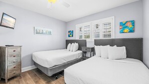 A hotel room with two beds, a dresser, a nightstand, and artwork on the walls. - 2BR Gulf-side condo w private beach access & heated pool (Gulf Shores)