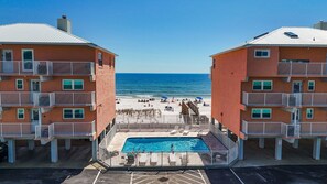 A beachfront hotel with a swimming pool, beach access, and multiple balconies. - 2BR Gulf-side condo w private beach access & heated pool (Gulf Shores)