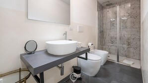 A modern bathroom with a large mirror, a round sink, a toilet, and a shower area. - Estay - The Corner House Cagliari Room 2 (Cagliari)