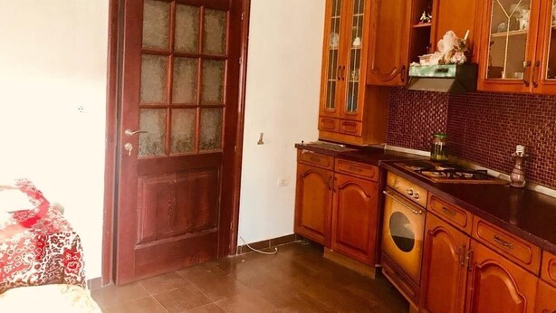 Une cuisine avec des meubles de rangement en bois, une cuisinière et un four à micro-ondes.