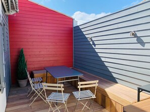 A patio with a table and chairs, a potted plant, and a wooden bench. - Village house 300 meters from the beach.  Pets are allowed. (Sainte-Marie-de-Ré)