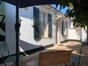 A courtyard with a bench, a table, and a chair. - Village house 300 meters from the beach.  Pets are allowed. (Sainte-Marie-de-Ré)