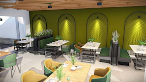 A modern interior with multiple seating areas, tables, and green walls with patterned designs.