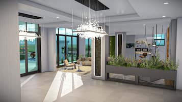 Interior moderno com balcão de recepção, área de estar e amplas janelas.
