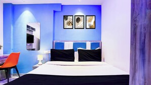 A hotel room with a bed, a desk with a chair, and a wall-mounted TV. - Collection O Goregaon Near Film City (Mumbai)