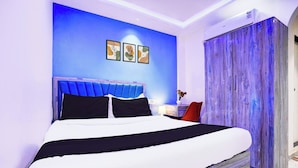 A modern bedroom with a bed, a nightstand, a lamp, and a wardrobe. - Collection O Goregaon Near Film City (Mumbai)