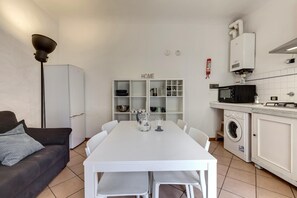 A compact kitchen with a white table, a washing machine, and a microwave. - Ginori 3 G in Firenze (Florence)