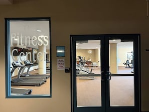 Ein Fitnessstudio mit Laufbändern, Trainingsgeräten und einem Schild, das darauf hinweist, dass die Geräte nicht von Personen unter 16 Jahren genutzt werden dürfen.