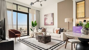 Ein modernes Wohnzimmer mit einer Couch, einem Couchtisch und einem Essbereich mit Tisch und Stühlen.