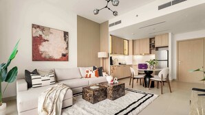 Ein modernes Wohnzimmer mit einer Couch, einem Couchtisch und einem großen, abstrakten Gemälde.