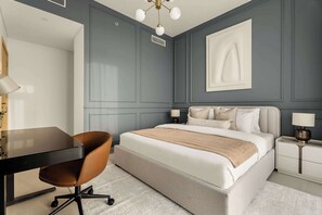 A modern bedroom with a bed, bedside tables, a desk, and a chair. - Silkhaus Premium 2BR in Golf Grand Dubai Hills (Dubai)