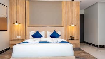 A hotel room with a large bed, two bedside tables, and a headboard.