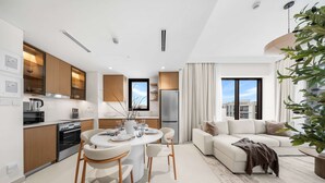 A modern apartment with a kitchen, dining area, and living room. - Free Housekeeping Visits During Your Stay - Stayshort - Peaceful 1-bedroom in Dubai Creek Harbour - Sleeps 4 (Dubai)