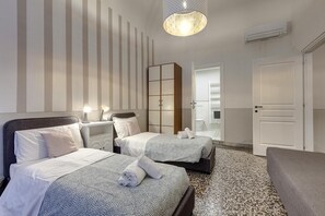 A hotel room with two beds, a nightstand, a wardrobe, and a door leading to a bathroom. - Proconsolo 9S in Firenze (Florence)