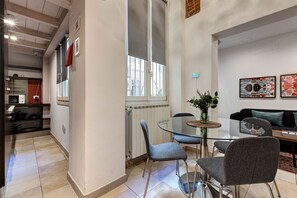 Eine moderne Küche mit Essbereich, inklusive Glastisch und grauen Stühlen.